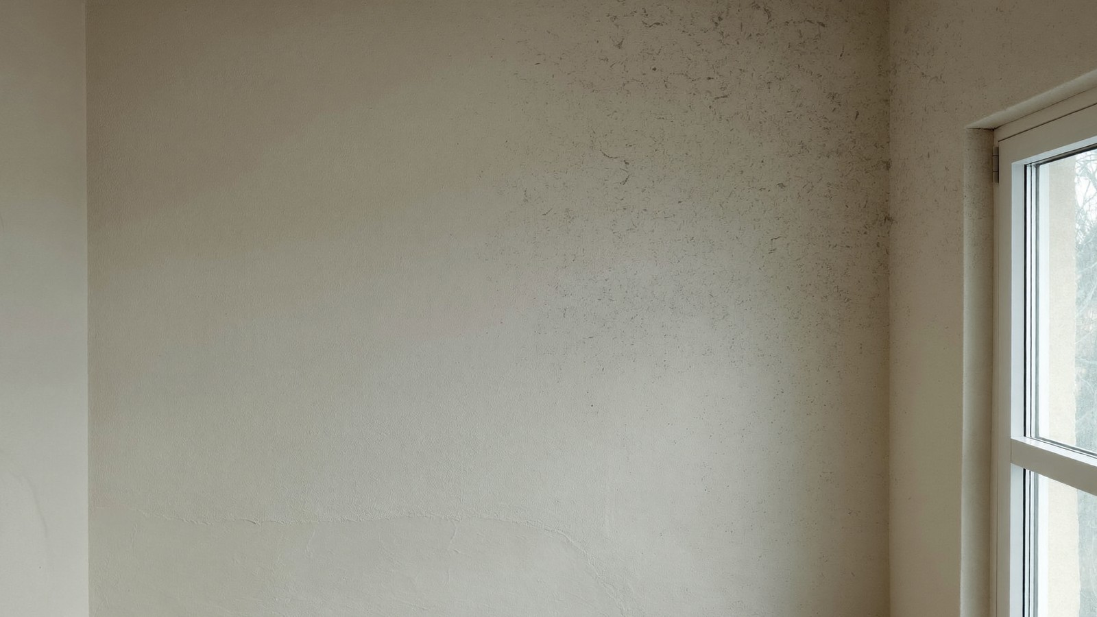 Esquina superior de una pared junto a la ventana con un sombreado gris incipiente por condensación